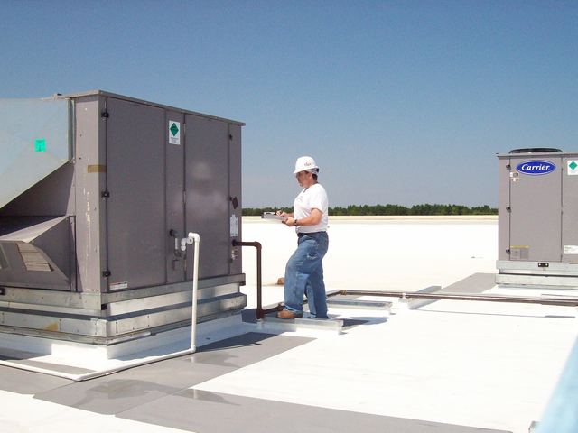 Mark F Gremillion at work among large rooftop units